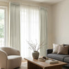 Custom Arden Satin Blackout Curtain in light neutral color, elegantly pleated and layered with sheer curtains for home decor.