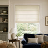 Natural linen Roman blind filtering light over a window in a modern living room